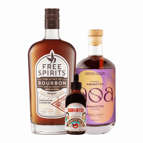Three bottles of non-alcoholic spirits. Free Spirits non-alcoholic Bourbon, NOA non-alcoholic Amaretto, and Bark & Bitter Aromatic Bitters