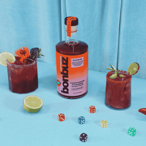 Bottle of Bonbuz non-alcoholic functional spirit with two cocktails and dice on a blue background