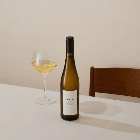 A bottle of Oddbird's non-alcoholic white wine, Presence, poured into a glass