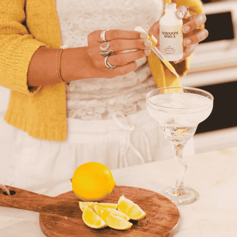 Shroom Soda Lemon Lime Adaptogenic Mushroom Drops being poured into a drink