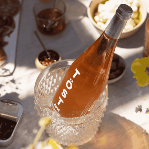 Bottle of TOST Rosé non-alcoholic sparkling white tea in a bucket with ice