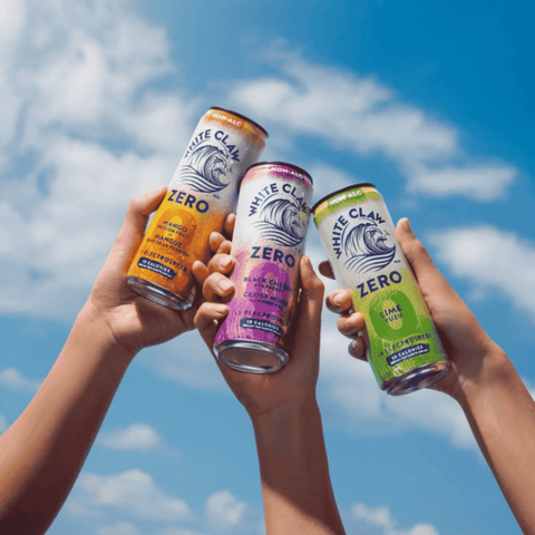 Three cans of White Claw Zero against a blue sky
