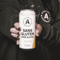 A person holding a can of Alchimiste Microbrasserie Gluten Free Non-Alcoholic Blonde