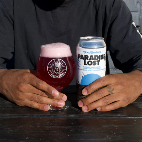 A can of Blood Brothers Paradise Lost Blueberry Vanilla Sour Non-Alcoholic Beer poured into a glass