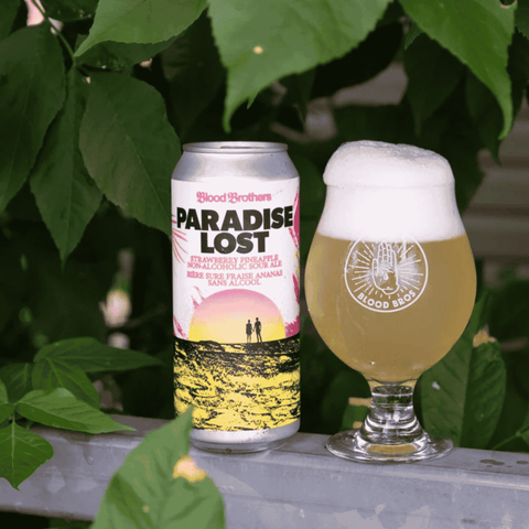 A can of Paradise Lost Non-Alcoholic Strawberry Pineapple Sour Beer by Blood Brothers poured into a branded glass