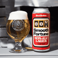 A can of Smooth Fortune Non-Alc Lager by Blood Brothers poured into a branded glass