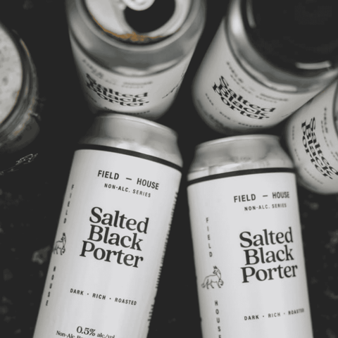 Cans of Field House Salted Black Porter arranged in a pile.