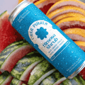 A blue can of Casa Pinata Mimosa Shrub displayed with fruit