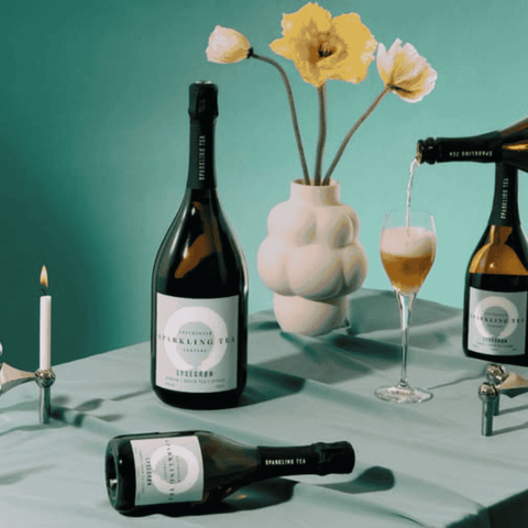 A bottle of Copenhagen LYSEGRØN Sparkling Tea poured into a Champagne flute