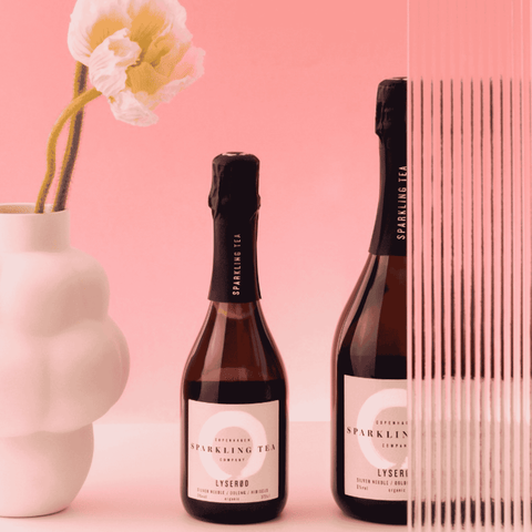 Two bottles of Copenhagen LYSERØD Sparkling Tea on a pink background