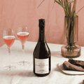 A bottle of Copenhagen LYSERØD Sparkling Tea poured into two flutes