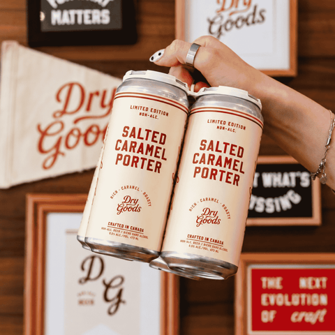 A peron holding a 4-pack of Dry Goods Salted Caramel non-alcoholic Porter