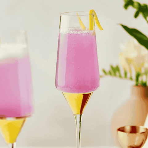 Two champagne flutes with bright pink non-alcoholic cocktails