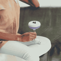 Person holding a purple non-alcoholic cocktail sitting on a couch