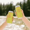 Two hands holding cans of Field House non-alcoholic Salted Lime Mexican Lager