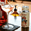 A can of non-alcoholic Strawberry Yuzu Collins by Fin Soda poured into a cocktail glass.