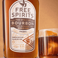 A bottle of Free Spirits non-alcoholic Bourbon with an old fashioned cocktail in a rocks glass
