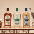 Three bottles of non-alcoholic spirits by Free Spirits displayed on a bar cart with glassware