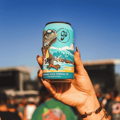 A person holding a can of Sunshine State non-alcoholic Tropical IPA