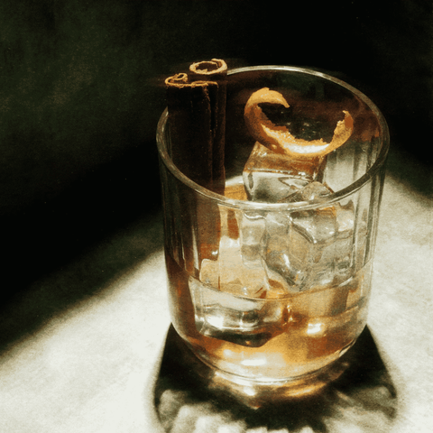 Mad Moose Non-Alcoholic Whiskey mixed into a cocktail in a rocks glass with ice, cinnamon, and an orange twist.