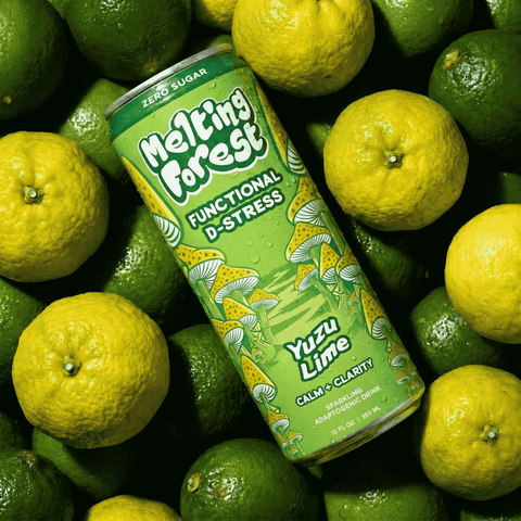 A can of Melting Forest Functional D-Stress Yuzu Lime sparkling beverage is surrounded by a pile of fresh limes.