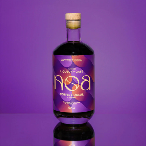 A bottle of NOA Non-Alcoholic Coffee Liqueur on display with a purple background