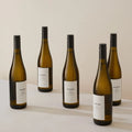 Five bottles of Oddbird non-alcoholic white wine displayed on a table
