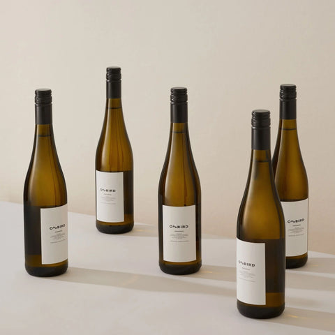 Five bottles of Oddbird non-alcoholic white wine displayed on a table