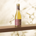 A bottle of Saicho Sparkling Darjeeling Tea 200 mL on a wood shelf