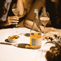 A bottle of Saicho Sparkling Hojicha Tea on a table with green olives