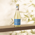A bottle of Saicho Sparkling Jasmine Tea 200 mL on a wood shelf