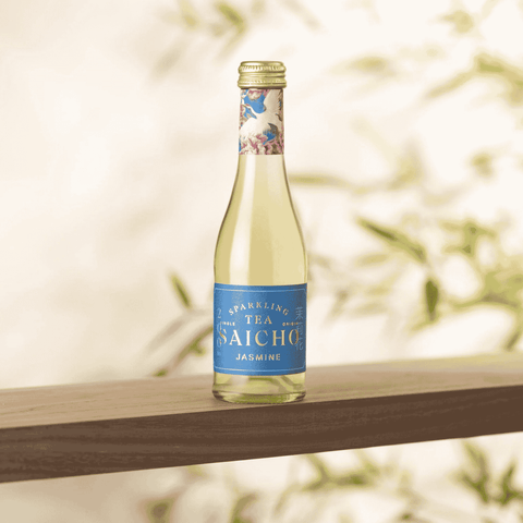 A bottle of Saicho Sparkling Jasmine Tea 200 mL on a wood shelf