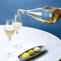 A boggle of Saicho Sparkling Jasmine Tea being poured into two glasses paired with dessert