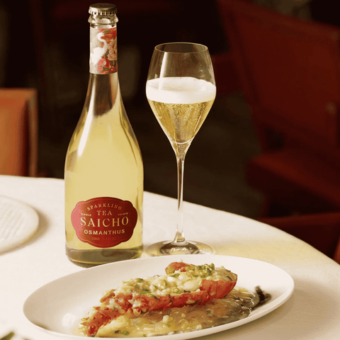 A bottle of Saicho Sparkling Osmanthus Tea poured into a glass paired with a seafood dish