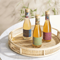 Three bottles of Sparkling Tea by Saicho on a woven tray