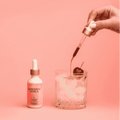 A bottle of Shroom Soda Black Cherry being poured into sparkling water