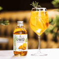 A bottle of Sir James 101 non-alcoholic Aperitif Spritz poured into a wine glass with ice and a sprig of rosemary