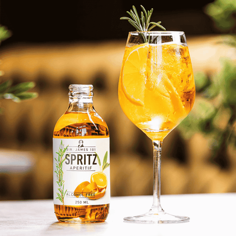 A bottle of Sir James 101 non-alcoholic Aperitif Spritz poured into a wine glass with ice and a sprig of rosemary