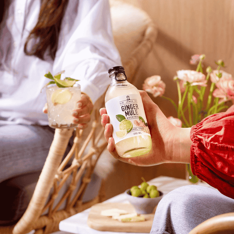 A person holding a bottle of Sir James 101 non-alcoholic Ginger Mule