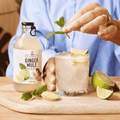 A bottle of Sir James 101 non-alcoholic Ginger Mule poured into a rocks glass and garnished with a mint sprig