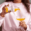 A bottle of Sir James 101 non-alcoholic Passionfruit Martini being poured into a cocktail glass