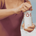 A person opening a can of TOST Rose Sparkling Tea