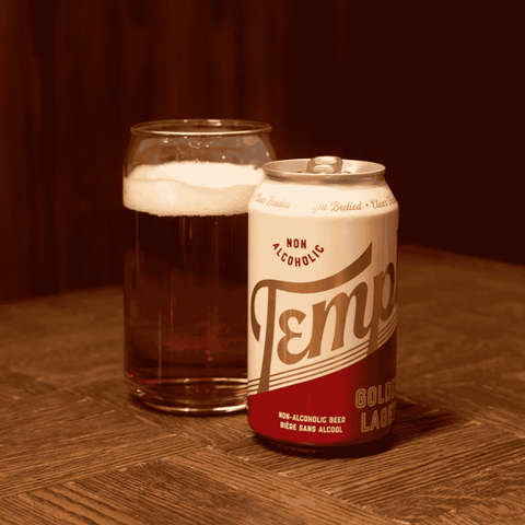 Can of Templ non-alcoholic beer with a glass of beer on a wooden surface